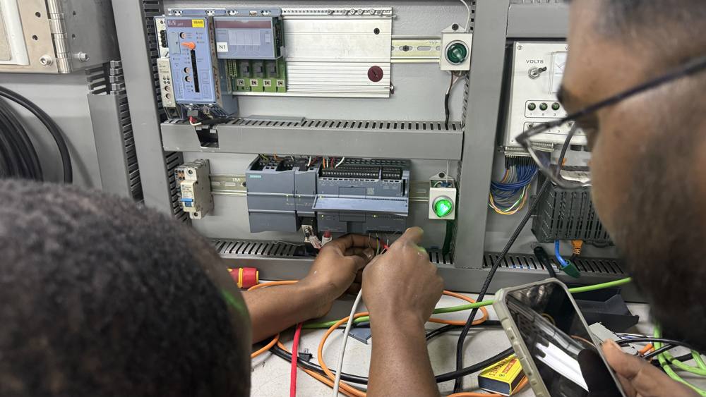 KlareTech technicians wiring and fault-finding a PLC control panel